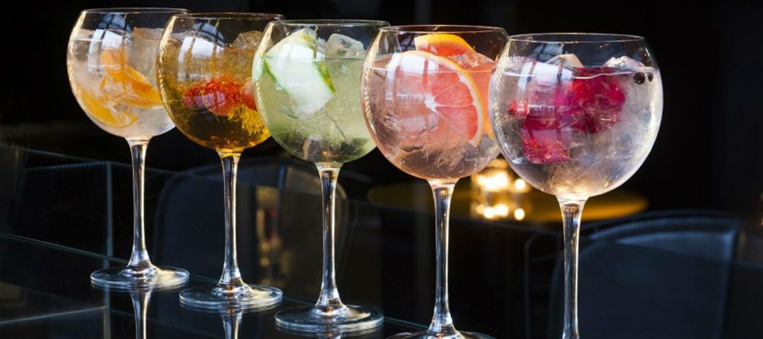 Bicchieri di gin tonic di vari colori sono esposti sul bancone del bar di  un pub o di un ristorante